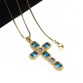 Close-up of golden cross pendant with blue zircons and lobster clasp on link chain - Sky Blue