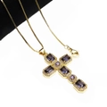 Close-up of gold cross necklace with purple zircon stones and sparkling diamond accents - Purple