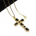 Detail of gold cross pendant with black zircon stones and micro-set white crystals - Black