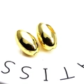 Macro shot of polished 18K gold plated teardrop earrings on a white ceramic tray - Oval Bean Style (5)