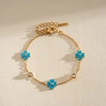 Detalle de pulsera de acero dorado con flores de esmalte azul y detalles de circón. - Flor Azul / Azul