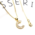 Macro shot of gold letter C pendant necklace with cubic zirconia and box chain - Letter C