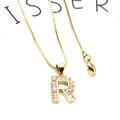 Foto macro de collar con colgante letra R dorado con circonitas y detalle cadena box - Letra R