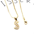 Detalle del colgante letra S dorado con circonitas rectangulares en una cadena de caja - S