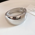 Close-up of a minimalist chunky polished silver wide metal bangle with a spring hinge. - 2# Bracelet-Silver