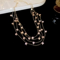 Close-up van een elegante gelaagde gouden ketting met roze zirkonia steentjes. - Roze