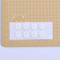Weiße kreisförmige doppelseitige Klebepunkte für DIY-Handwerk auf gelber Matte - Standardpaket