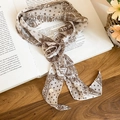 Detail of elegant skinny silk scarf with brown paisley and dot prints on vintage book - White Coffee Print