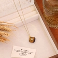 Detail view of a square tiger eye stone pendant necklace on a jewelry box liner. - Tiger's Eye
