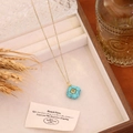 Detailed view of geometric square stone necklace with gold chain in wooden jewelry box - Blue Turquoise