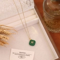 Nahaufnahme eines grünen quadratischen Steinanhängers an einer goldenen Edelstahlkette. - Malay-Jade
