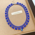 Macro view of elegant blue and gold glass beaded lace necklace with teardrop crystal - Blue