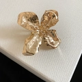 Detail view showing the hammered gold texture of an oversized metal flower ring on a white box - Ring (5#) / Gold