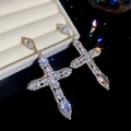 Gros plan de boucles d'oreilles croix argentées de luxe avec des strass étincelants - 39# Tige en Argent Sterling 925 - Croix de Luxe / Or