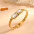 Detailed view of a gold-plated stainless steel bangle with Greek key engraving - Meander Square Style (F612) / Gold (White Square Stone)