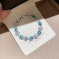 Elegantes Blumenarmband mit grünen Edelsteinen und Zirkonia-Verzierungen. - Smaragd Ovaler Halo-Stil (48#)