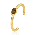 Professional close-up of a gold C-shaped cuff bracelet featuring an oval tiger's eye stone - Tiger Eye Stone Style