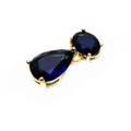 Macro view of teardrop blue zircon pendant with gold prong setting and oval gem detail - Blue