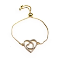 Close-up of golden adjustable heart bracelet featuring micro-paved cubic zirconia stones - Double Overlapping Hearts Pave Zircon Style (18) / Gold