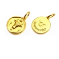 Macro detail of gold Taurus zodiac pendant with embossed bull and Trustworthy engraving - Taurus