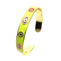 Detail of green enamel cuff bracelet with colorful evil eye and Hamsa hand charms - Yellow