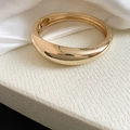 Detailed view of a glossy gold irregular geometric bangle with high-end polished metal finish - Style 3 / Gold
