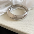 Close-up view of a minimalist silver irregular geometric metal bangle with a high polished finish - Bracelet / Silver