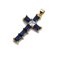Colgante de cruz dorada con circonitas azules rectangulares y piedra blanca en fondo blanco - Azul