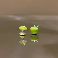 Detailed macro view of asymmetric green apple and apple core enamel stud earrings - Asymmetric Apple Style (HE32372-) / Green