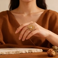 Dettaglio ravvicinato di un anello a fiore in acciaio al titanio dorato vintage con pietra - Stile Fiore Strass C617