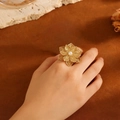 Vista dettagliata dell'anello a fiore placcato in oro con perla su mano femminile - Stile Fiore Perla C617