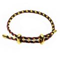Close-up of black, yellow, and red braided rope bracelet with gold metal slider buckles - Black/Yellow/Red