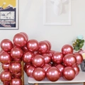 Pack of metallic rose red latex balloons for party decoration displayed in a gold basket - Red