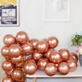 Bunch of shiny rose gold metallic latex balloons in a decorative golden basket for parties - Rose Gold
