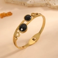 Detailed macro shot of gold titanium steel bangle with two faceted black stones. - 3D Curve Round Style (F613) / Gold (Black Rhinestone)