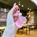 Dettaglio del portachiavi a tazza di tè rosa con glitter liquidi e paillettes a stella - Rosa