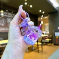 Dettaglio del portachiavi a tazza viola con glitter liquidi, fiori secchi e campanellino - Viola