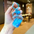 Dettaglio portachiavi blu con sabbie mobili liquide e paillettes a stella in mano - Stile Chiusura a Moschettone / Blu