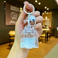 Detail of liquid quicksand keychain featuring castle shape with white bell and sequins - Lobster Clasp Style / White