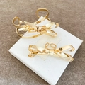 Close-up detail of a gold bow-shaped cuff bracelet and matching ring set on a gift box. - Bowknot Wrap Bangle and Ring Set (69#) / Gold