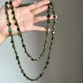 Detail of a bohemian long necklace with green shell beads and amber accents. - Green Brown