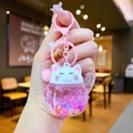 Close-up of cute Maneki Neko liquid keychain with pink glitter and star sequins - Colored Hardware Luminous Style / Pink
