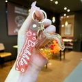 Detail van capibara sleutelhanger met vloeibare glitters en oranje siliconen band - Gradiënt Band / Aardbei Capybara Huis