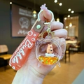 Detail van de capybara vloeibare sleutelhanger met oranje vloeistof en sterglitters - Gradiënt Band / Houten Vis Capibara Wekker