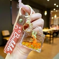 Detalle del llavero de Capibara con arena líquida naranja y purpurina dorada - Pulsera con degradado / Estilo Carpincho Cola