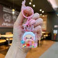 Close-up of pink liquid oil keychain with sheep doll, dolphin charm and small bell - Dazzling Night Light Flashing Quicksand