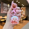 Close-up of pink liquid quicksand keychain with cute cartoon character and bell - Pink Night Light Flashing Quicksand