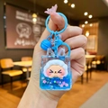 Macro shot of blue glitter liquid keychain with cute white lamb and metal bell - Blue Night Light Flashing Quicksand
