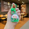 Close-up of green liquid cartoon keychain with floating stars and a cute smiling face - Green Night Light Flashing Quicksand