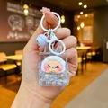 Close-up of a liquid oil keychain with cartoon sheep and colorful glitter sequins - White Night Light Flashing Quicksand